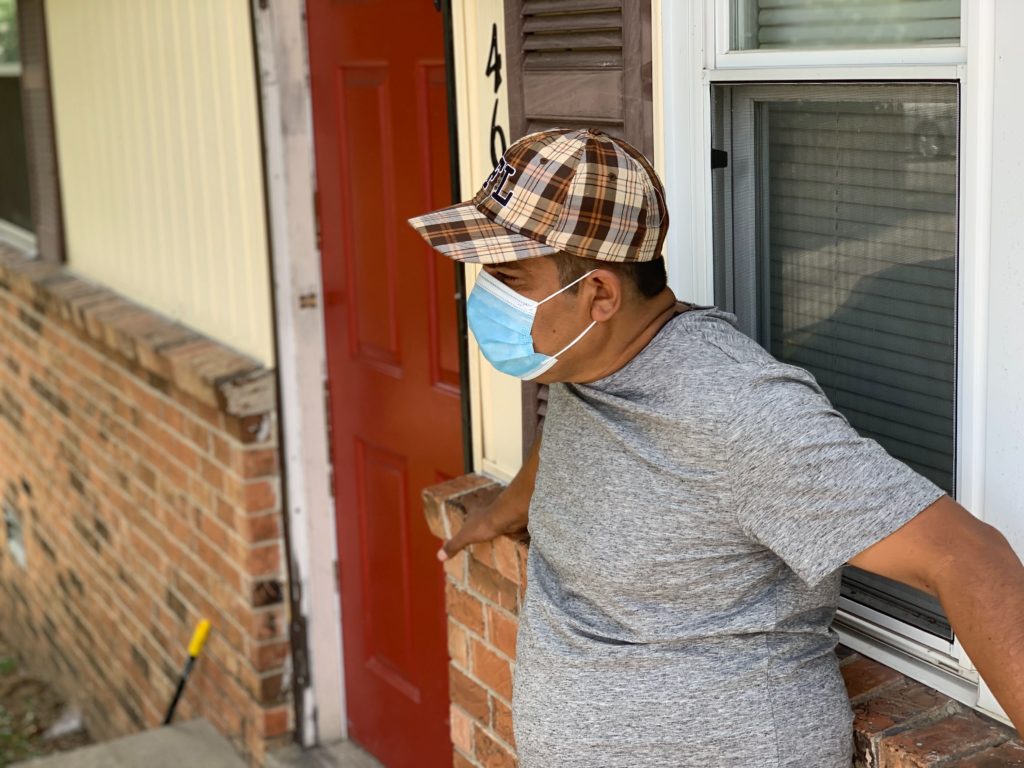 A man from Madison stands in front of his home in a face mask.