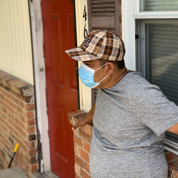 A man from Madison stands in front of his home in a face mask.