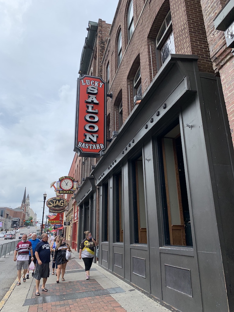 A group of people walks past a bar in downtown Nashville.