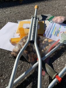 A pile of items submitted to Brezinka's art project, including a crutch, a bag of wine corks, empty pill bottles, a letter with results from a standardized test