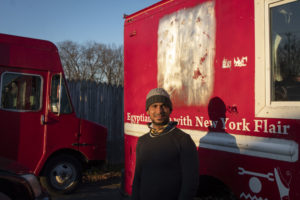 Business owner Ragab Rashwan stands in front of his food truck and restaurant.