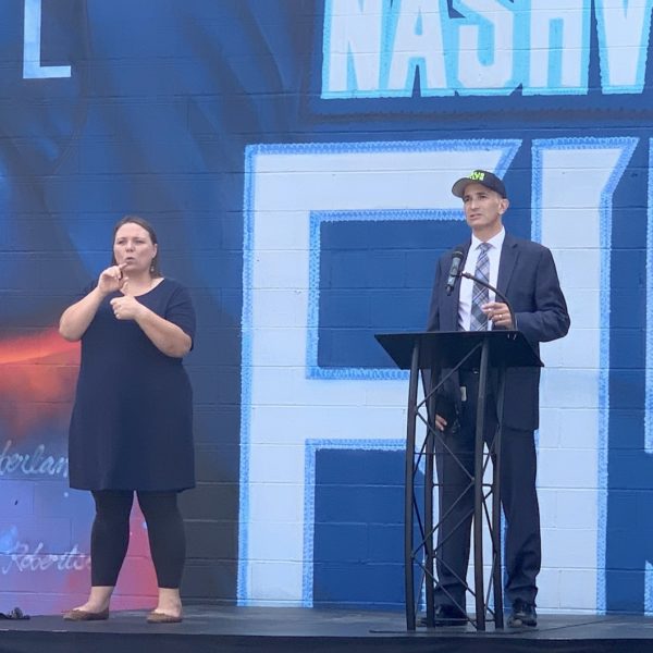 Dr. Michael Caldwell speaks in front of a Tennessee Titans mural.