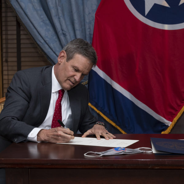 Governor Bill Lee signs paperwork swearing in John DeBerry as his special advisor.