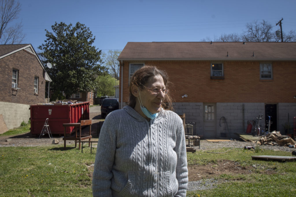 Katy Green stands in front of her belongings and garden that were damaged in March's flood.