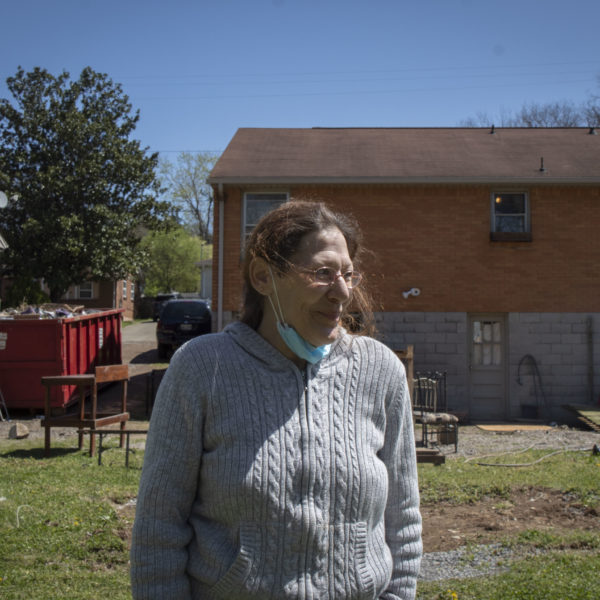 Katy Green stands in front of her belongings and garden that were damaged in March's flood.