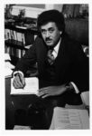 black and white image of Fred Humphries when he was president of TSU, seated and writing on a pad of paper