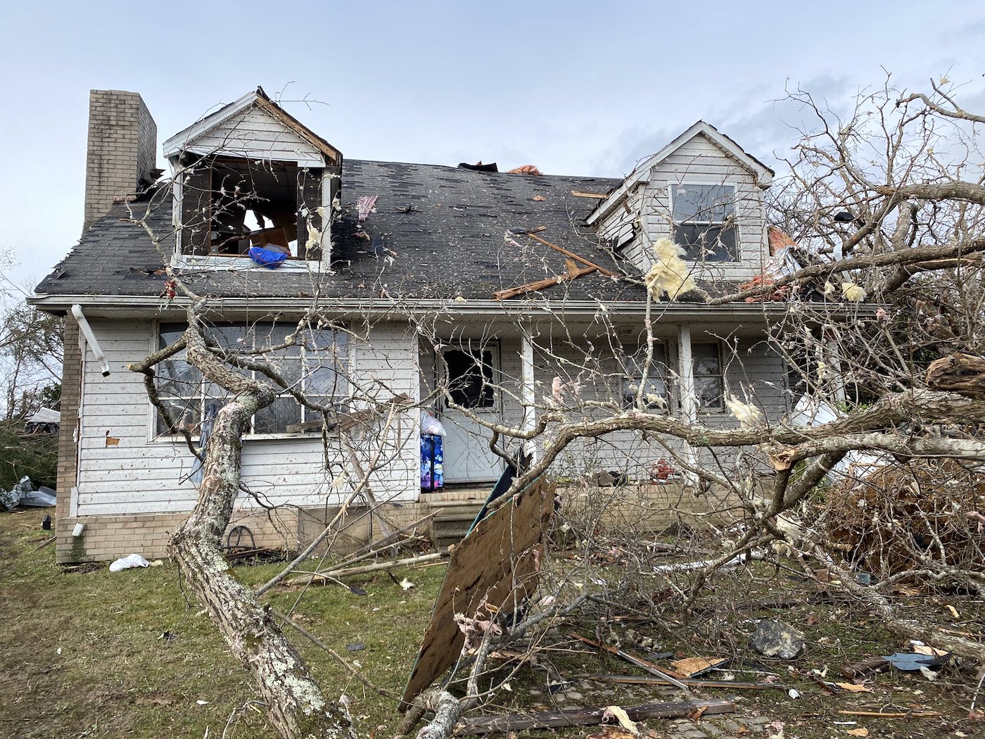 A home in Kingston Springs, Tennessee, with a fallen tree in the front yard and damaged windows.