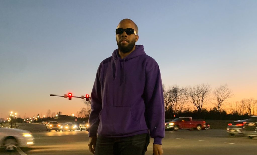 Quinn Howard standing in front of a busy intersection near his apartment.