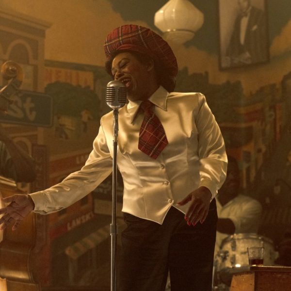 Shonka Dukureh in costume as Big Mama Thornton, singing in front of a vintage microphone