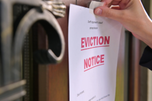 Woman places eviction notice on a door.