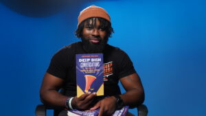 Jerome Moore, host of the podcast Deep Dish Conversations, holds his new Deep Dish Conversations book.