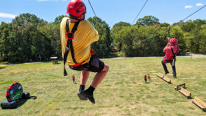 A camper races a counselor down the zip line at Camp Forget-Me-Not.