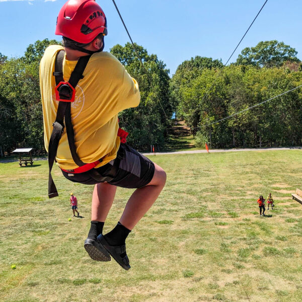 A camper races a counselor down the zip line at Camp Forget-Me-Not.