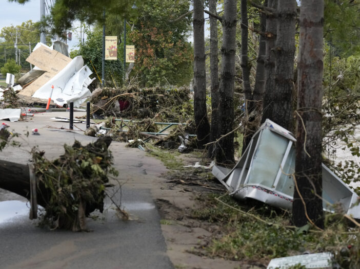 Uprooted trees and debris along a road left behind after flood waters receded