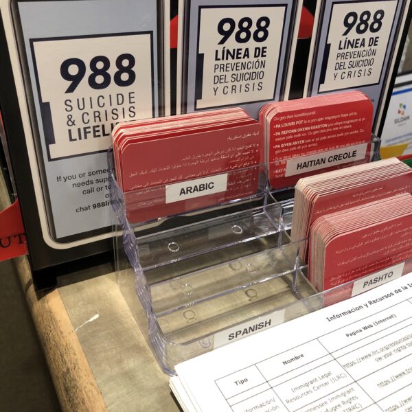 A clear plastic box with red business cards. Labels show each language the cards are written in.