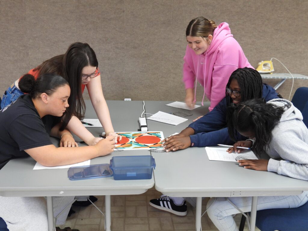 Paducah Tilghman High School students measure angles on display in quilt during a field trip to the National Quilt Museum.