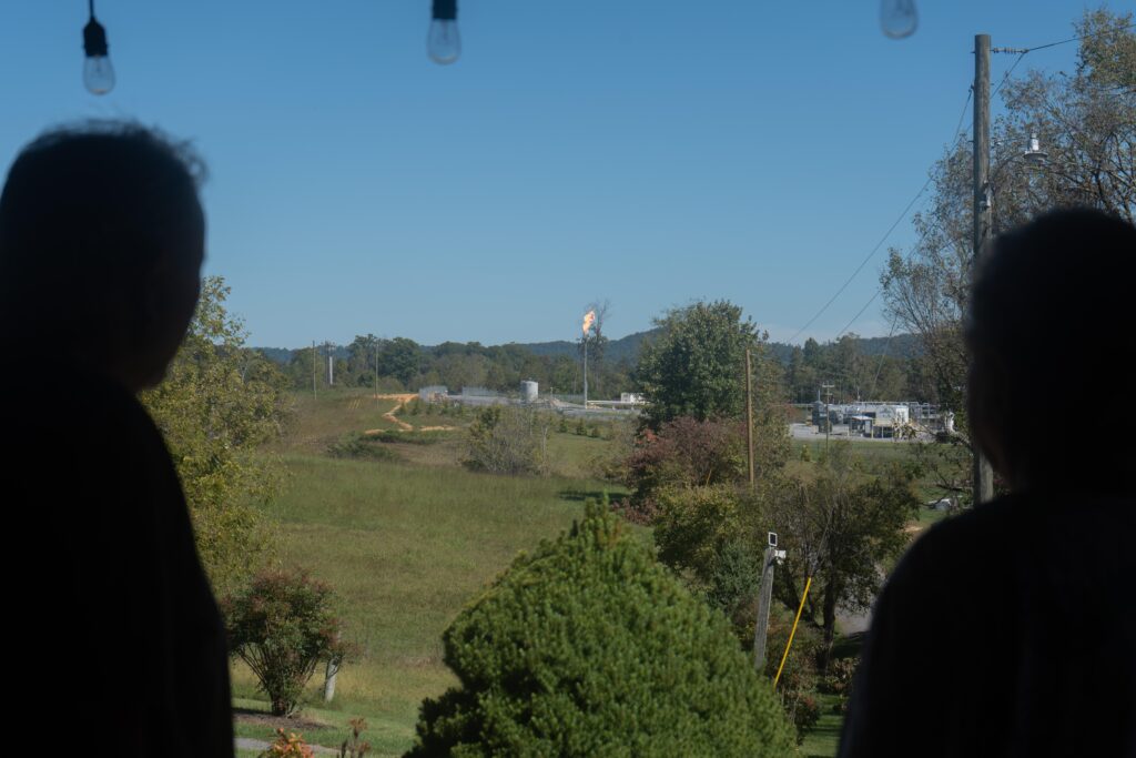 Mike (left) and Cynthia Trentham (right) look out at a fractionation plant operated by the NGL Supply Co., which moved in across the street from their family farm in Bulls Gap, Tenn., last year. They say the flame burns day and night, casting harsh light through their windows as they sleep and disturbing their cattle.