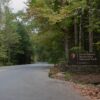 An entrance sign to Great Smoky Mountains National Park on a roadside surrounded by forest.
