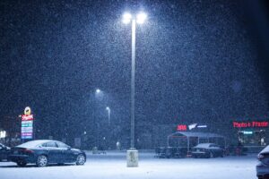 Snow falls on an empty parking lot outside a supermarket in December in Northvale, N.J.