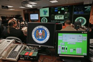 A monitor at a computer workstation bears the National Security Agency logo inside the Threat Operations Center.