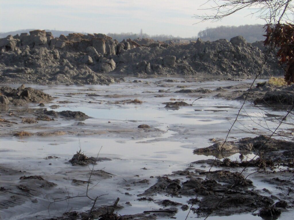 A 25-foot wall of ash at the site of the 2008 Kingston coal ash spill. TVA contractors worked for years to clean up the toxic ash, in many cases without masks or gloves to protect their health.