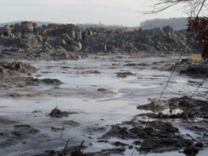 A 25-foot wall of ash at the site of the 2008 Kingston coal ash spill. TVA contractors worked for years to clean up the toxic ash, in many cases without masks or gloves to protect their health.