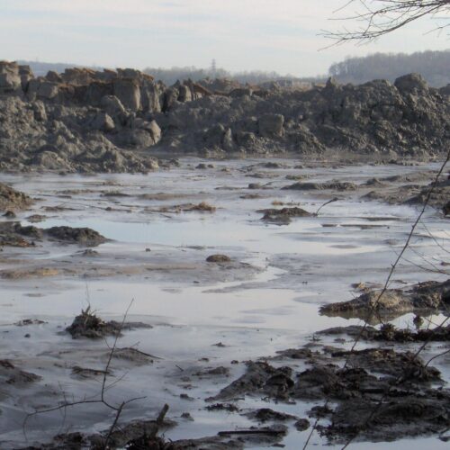 A 25-foot wall of ash at the site of the 2008 Kingston coal ash spill. TVA contractors worked for years to clean up the toxic ash, in many cases without masks or gloves to protect their health.