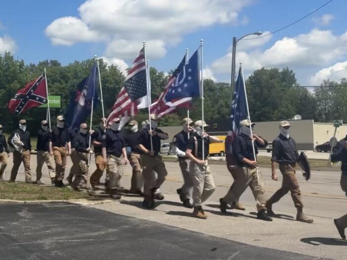 Masked members of the white nationalist organization Patriot Front march down Munfordville's Main Street on May 9th to the town's old city hall, carrying flags associated with far-right and libertarian ideologies.