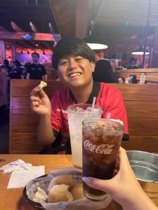 Rinta Goto, a tourist from Japan, enjoys what he describes as "insanely good" bread at Texas Roadhouse in Dallas.
