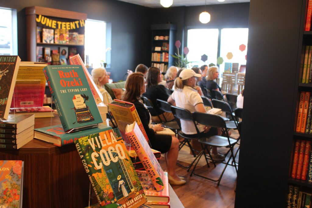 People sit in chairs during a book club gathering at the Hive Bookshop.
