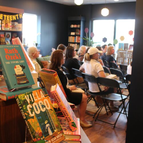 People sit in chairs during a book club gathering at the Hive Bookshop.