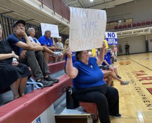 Mercer County residents hold up signs protesting a proposed data center at a planning and zonign commission meeting in Harrodsburg on July 30.