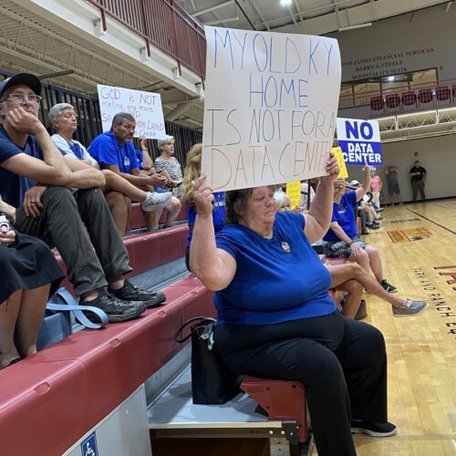 Mercer County residents hold up signs protesting a proposed data center at a planning and zonign commission meeting in Harrodsburg on July 30.