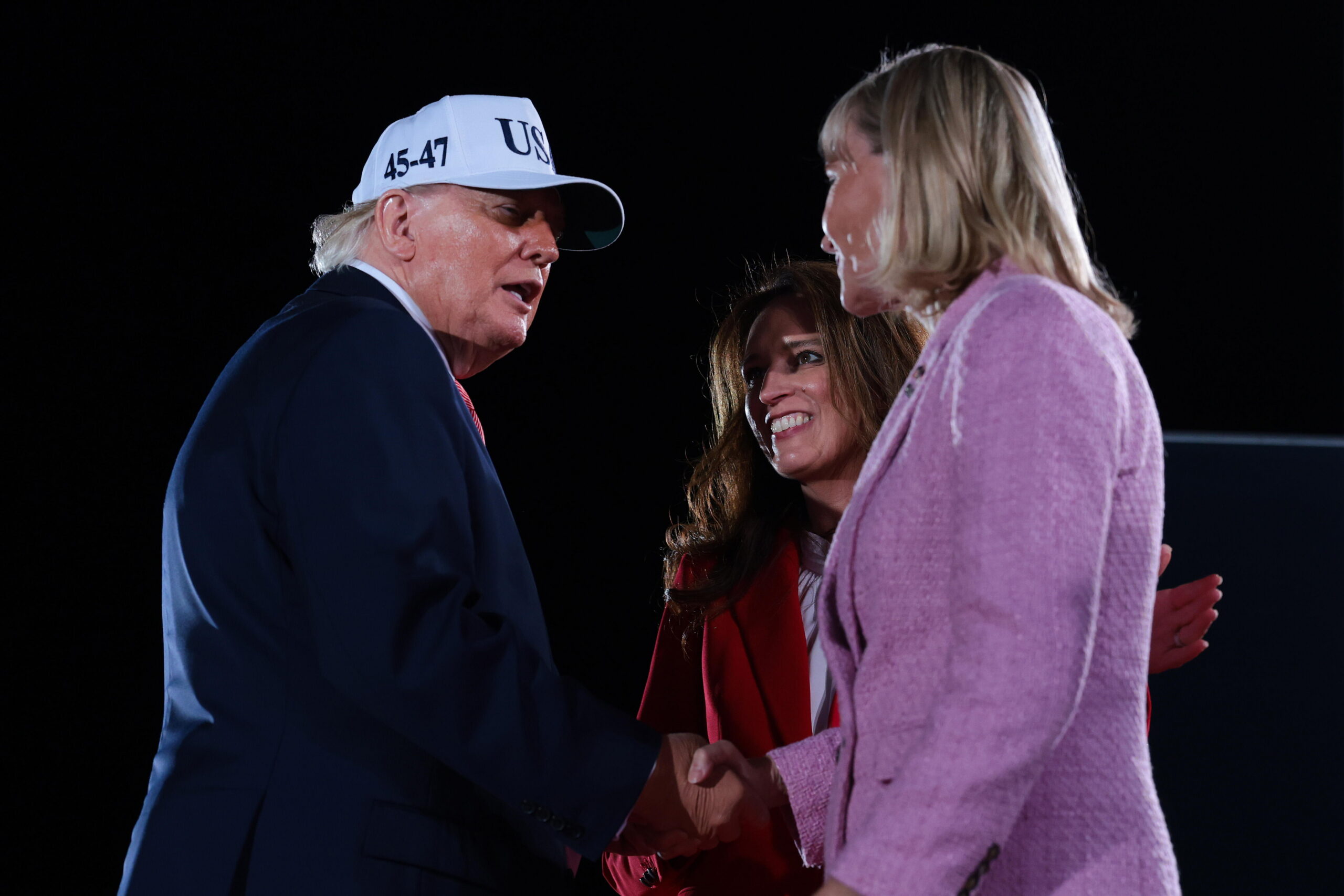 North Carolina Republican Congressional candidates, state Rep. Jennifer Balkcom and Laurie Buckhout (right), are embraced by President Trump during an election rally on Oct. 20, 2026, in Greenville, N.C.  Buckhout is running in North Carolina's 1st District, which was redrawn to heavily favor Republicans and is now a toss-up.